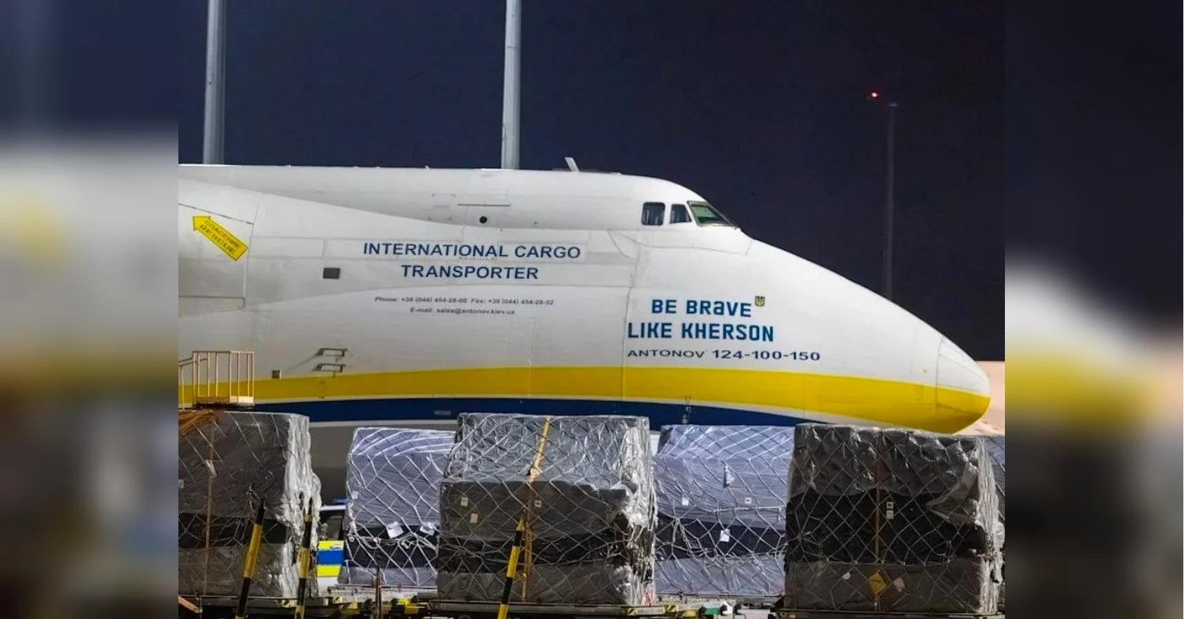 Білий Антонов-124 з написом Be Brave Like Kherson біля вантажних палет вночі